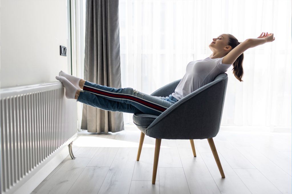 O tânără bucurându-se de căldura și confortul termic dintr-un apartament administrat eficient de Urban Hive Admin